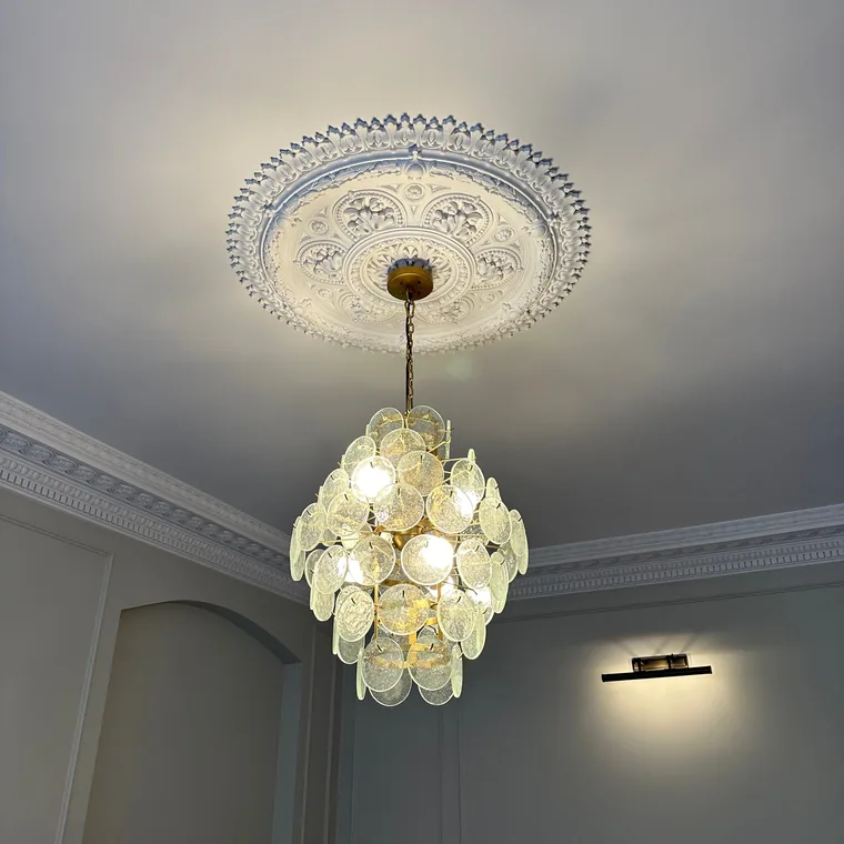 Glass light fitting installed into an ornate ceiling rose in a living room by HC Pyramid Electrical LTD